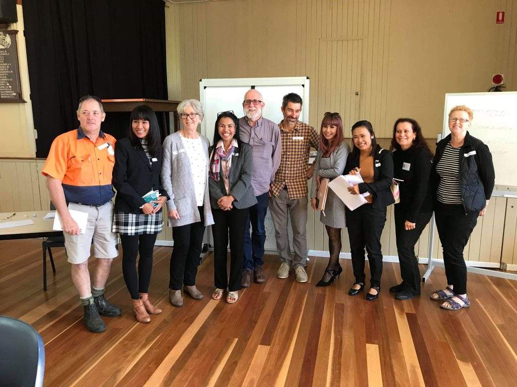 photo of a group of board members in a community hall in front of a whiteboard